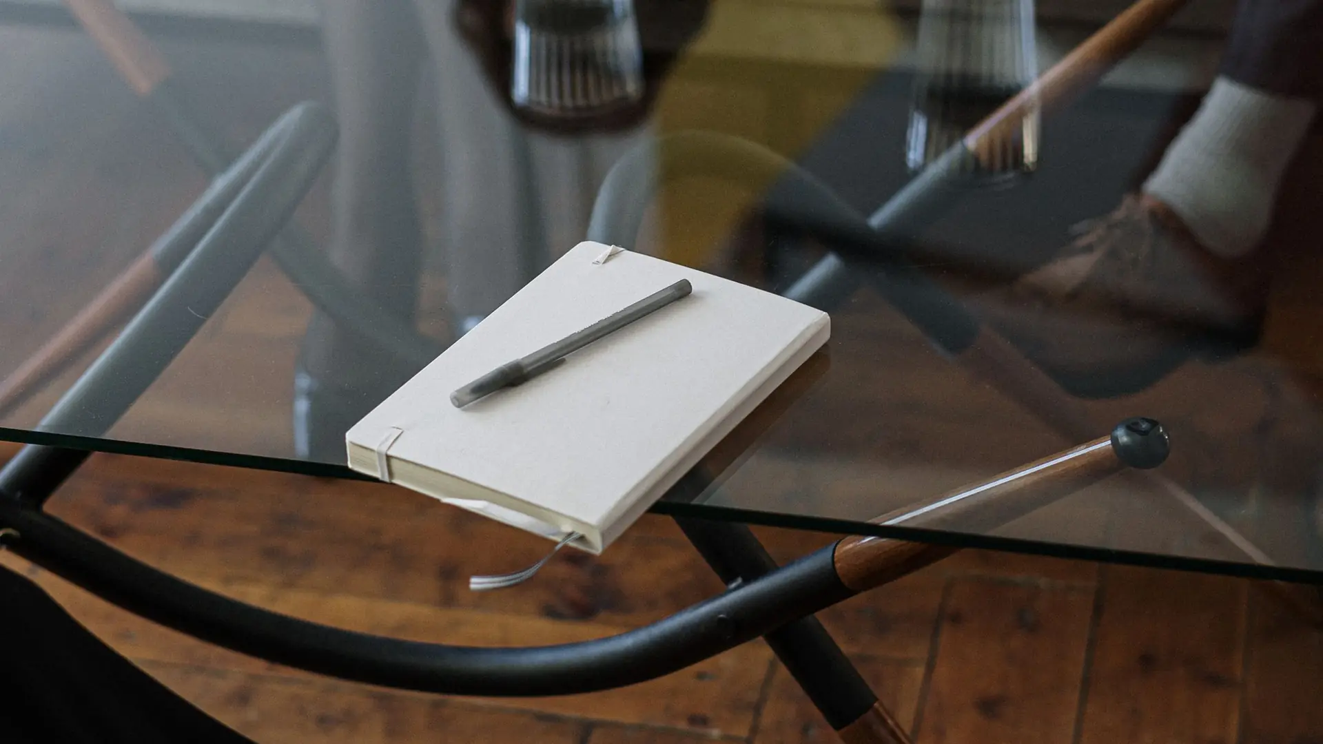 Cuaderno y bolígrafo sobre la mesa de una sala de consulta, antes de empezar la conversación